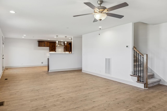 unfurnished living room with ceiling fan and light hardwood / wood-style floors