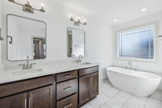 bathroom with tile patterned flooring, vanity, and a tub to relax in