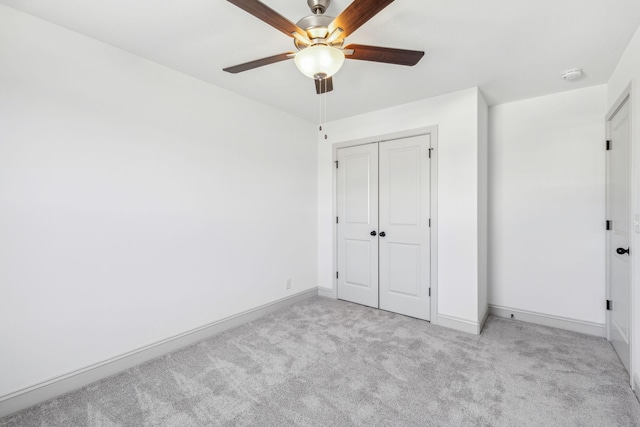 unfurnished bedroom with ceiling fan, a closet, and light carpet