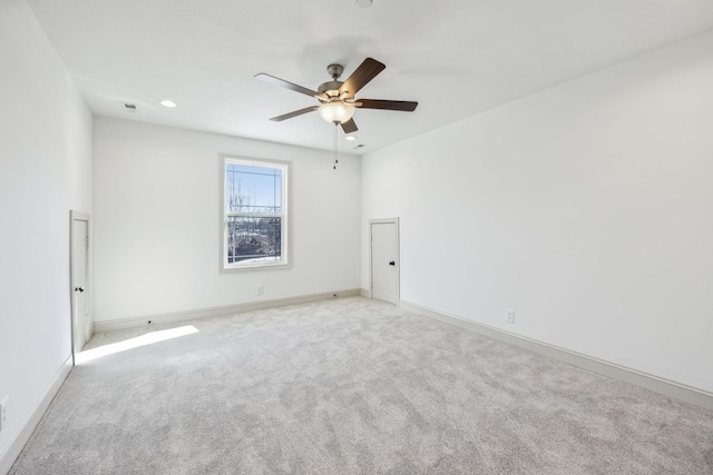 unfurnished room with light colored carpet and ceiling fan