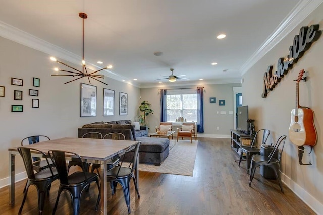 dining area featuring hardwood / wood-style flooring, ceiling fan with notable chandelier, and crown molding