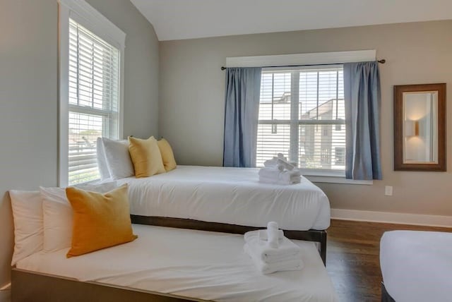 bedroom featuring dark wood-type flooring and vaulted ceiling