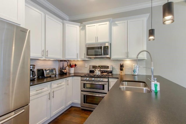 kitchen featuring white cabinetry, hanging light fixtures, stainless steel appliances, tasteful backsplash, and ornamental molding