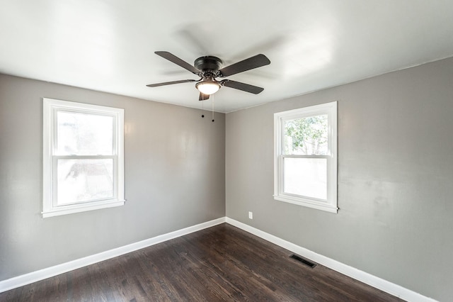 empty room with dark hardwood / wood-style floors and ceiling fan