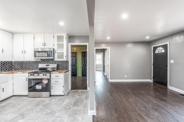 kitchen featuring tasteful backsplash, wooden counters, appliances with stainless steel finishes, and white cabinets