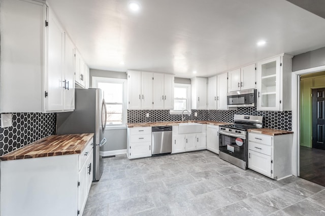 kitchen featuring butcher block counters, sink, white cabinets, and appliances with stainless steel finishes