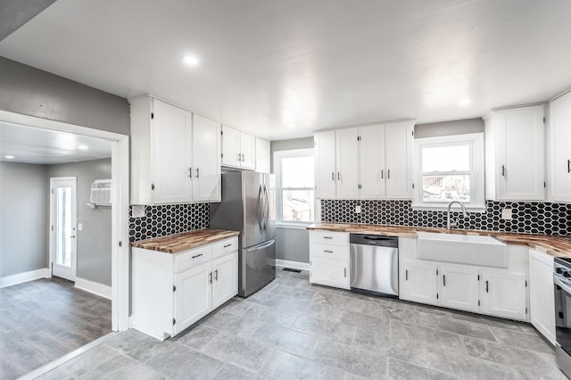 kitchen featuring appliances with stainless steel finishes, sink, and white cabinets