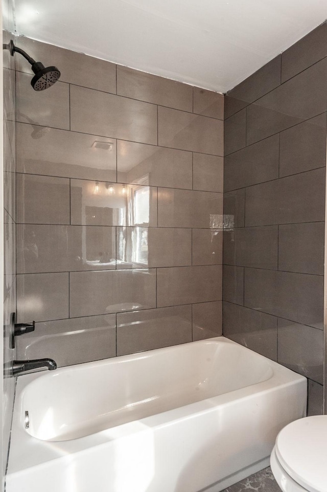 bathroom with tiled shower / bath and toilet