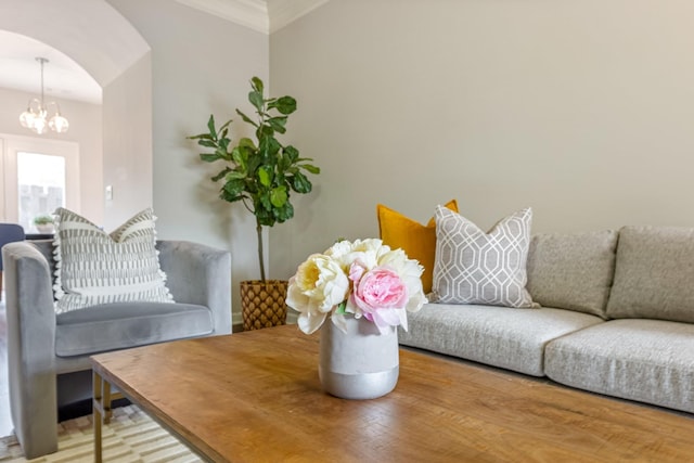 living room featuring a notable chandelier, crown molding, and hardwood / wood-style flooring