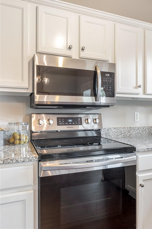 kitchen featuring light stone counters, white cabinets, and appliances with stainless steel finishes