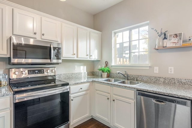 kitchen with stainless steel appliances, sink, and white cabinets