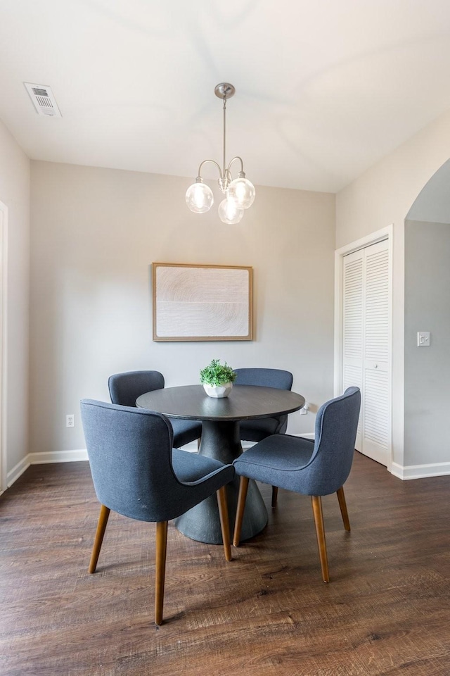 dining space with a notable chandelier and dark wood-type flooring