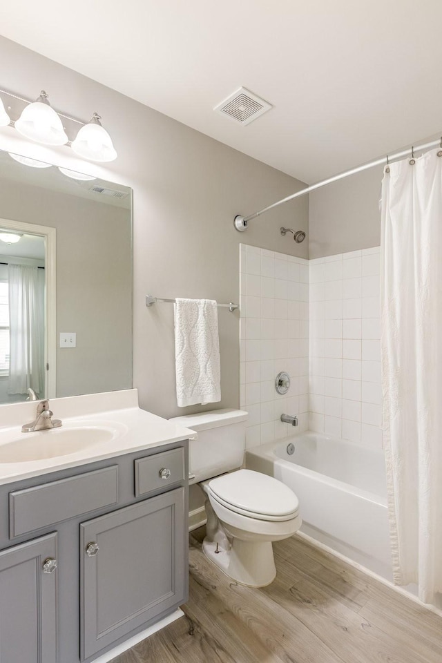 full bathroom with vanity, wood-type flooring, shower / bath combination with curtain, and toilet