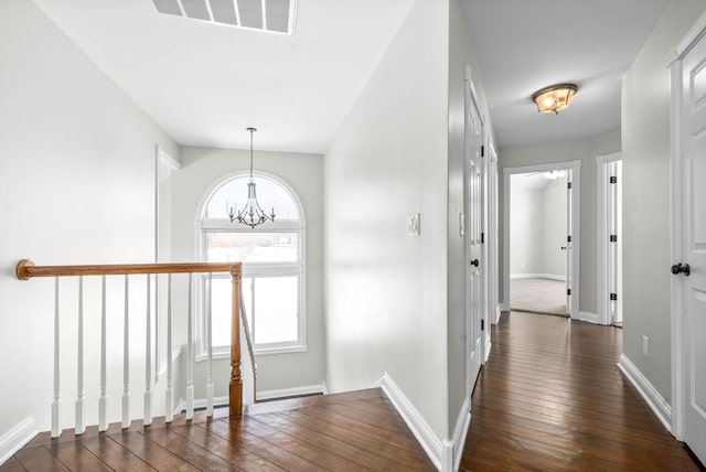 hall featuring dark hardwood / wood-style flooring, a chandelier, and plenty of natural light