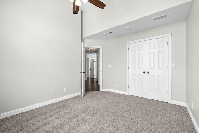 unfurnished bedroom featuring ceiling fan, carpet, and a closet