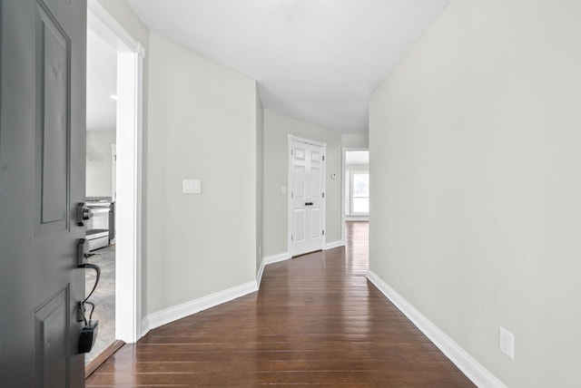 hallway with dark hardwood / wood-style flooring