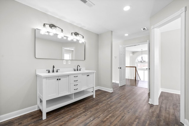 bathroom featuring wood-type flooring, vanity, and a notable chandelier