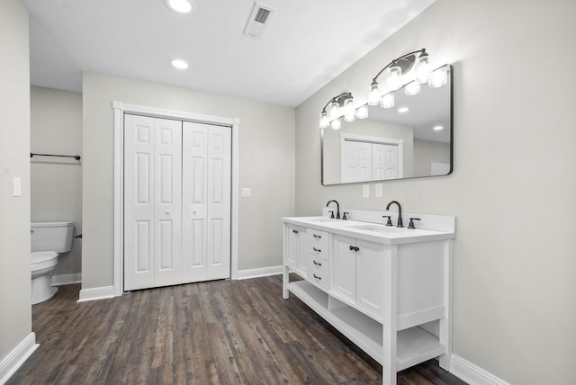 bathroom featuring wood-type flooring, toilet, and vanity