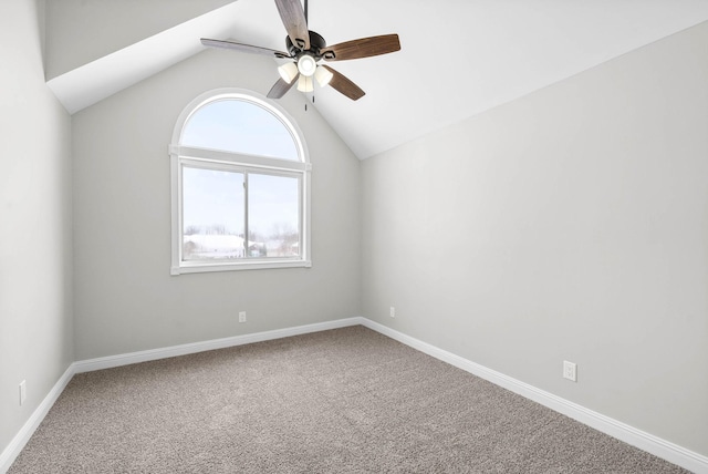 carpeted spare room with ceiling fan and vaulted ceiling