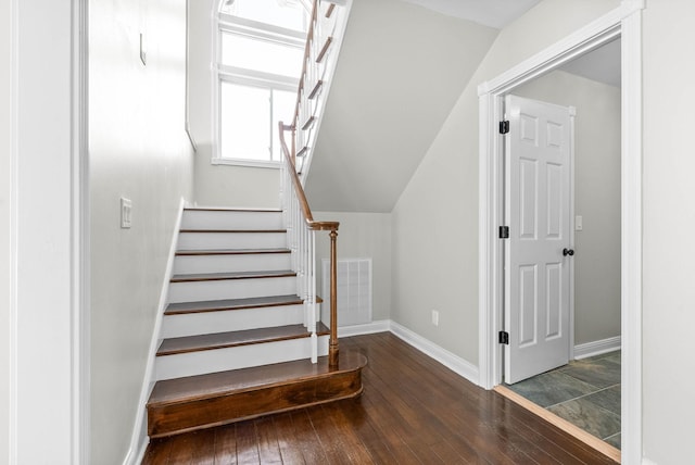 stairs featuring vaulted ceiling and hardwood / wood-style flooring