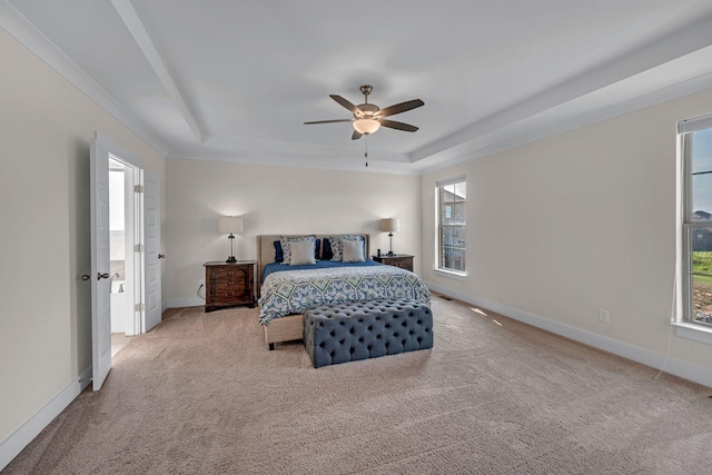 carpeted bedroom featuring multiple windows, a tray ceiling, and ceiling fan