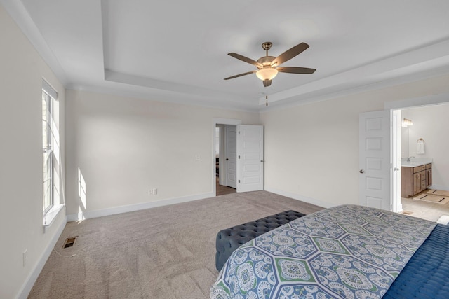 carpeted bedroom with ceiling fan, connected bathroom, and a tray ceiling