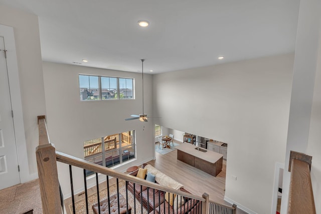 stairs featuring ceiling fan