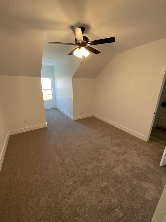 additional living space with ceiling fan, dark carpet, and lofted ceiling