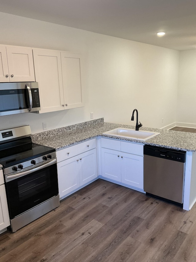 kitchen featuring white cabinets, appliances with stainless steel finishes, dark hardwood / wood-style floors, and sink