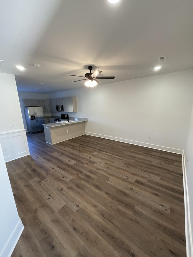 unfurnished living room featuring dark hardwood / wood-style floors and ceiling fan