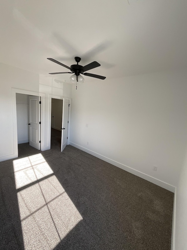 unfurnished bedroom with dark colored carpet and ceiling fan