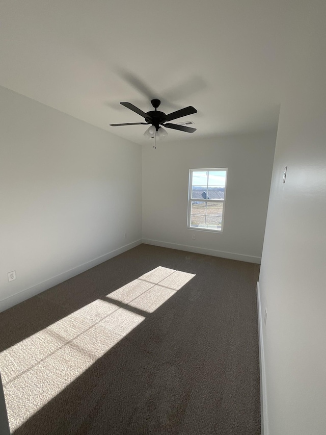 unfurnished room featuring dark colored carpet and ceiling fan