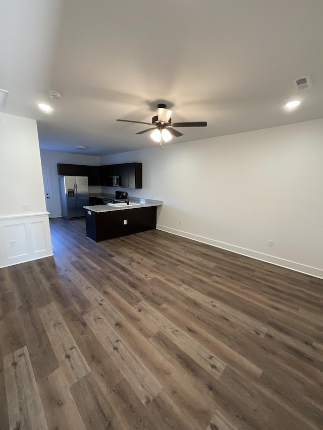 unfurnished living room with ceiling fan, sink, and dark hardwood / wood-style floors