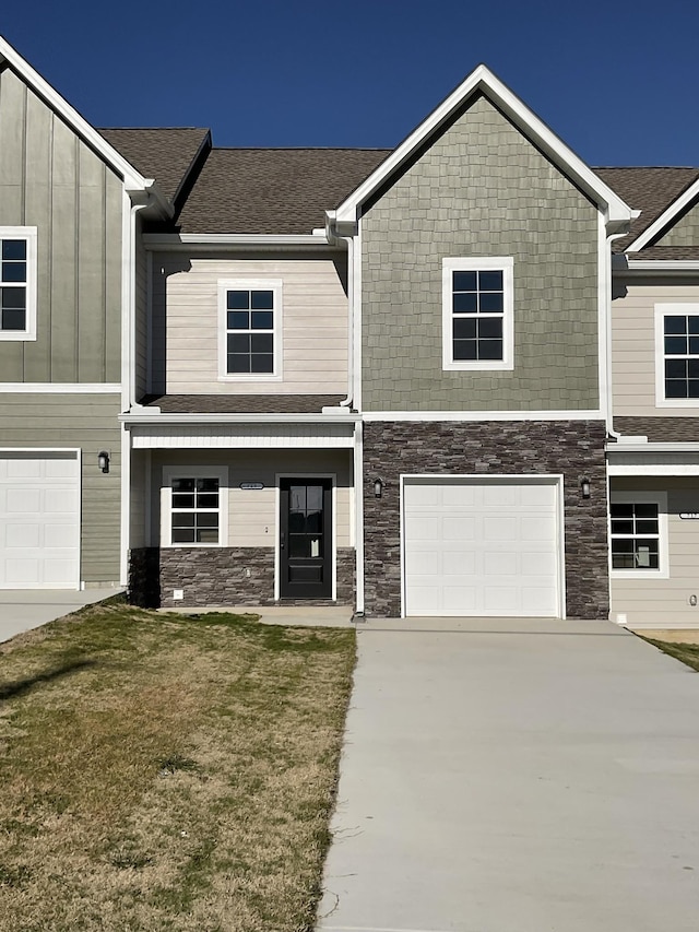 view of property with a garage and a front lawn