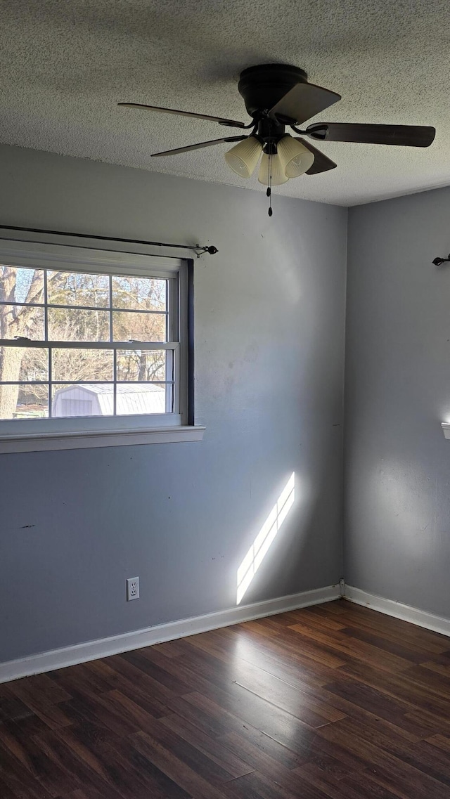 empty room with a textured ceiling and dark wood-type flooring