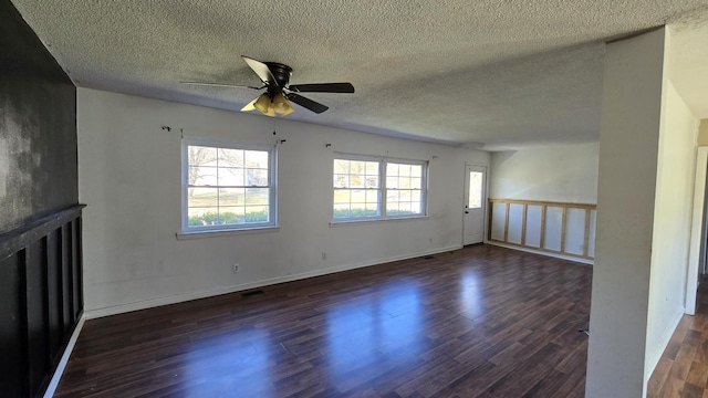 empty room featuring a textured ceiling, ceiling fan, and dark wood-type flooring