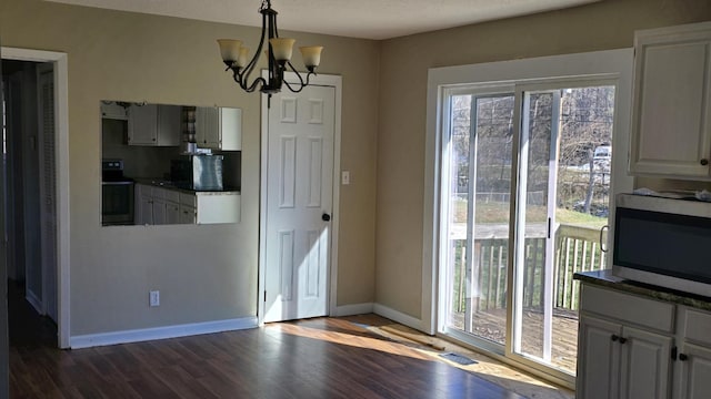 unfurnished dining area featuring dark hardwood / wood-style flooring and a notable chandelier