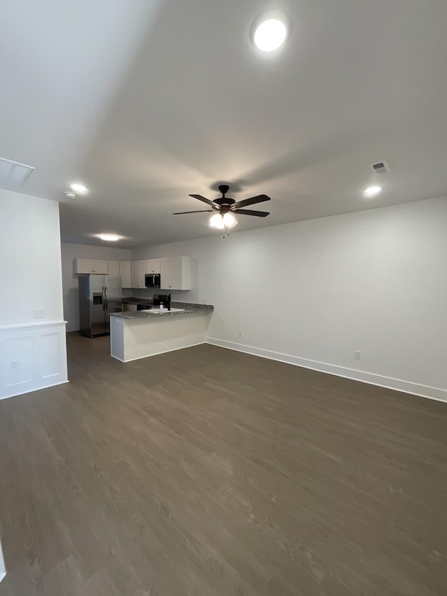 unfurnished living room featuring ceiling fan and dark hardwood / wood-style flooring