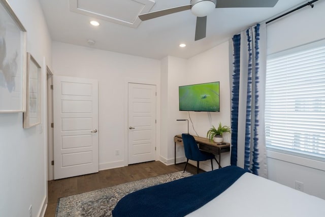 bedroom with ceiling fan, dark wood-type flooring, and multiple windows