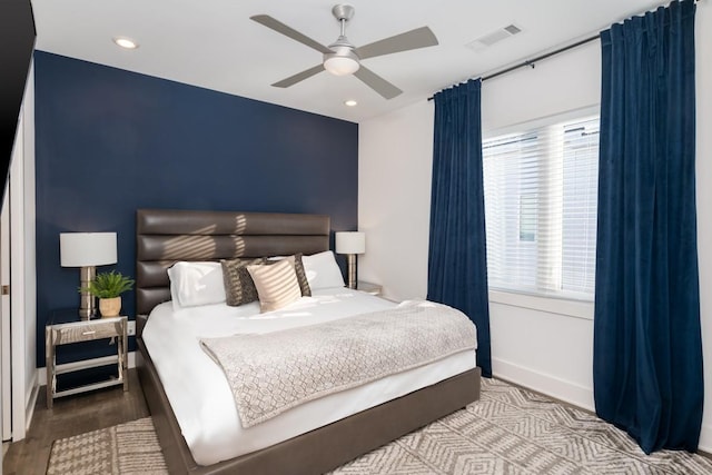 bedroom featuring multiple windows, wood-type flooring, and ceiling fan