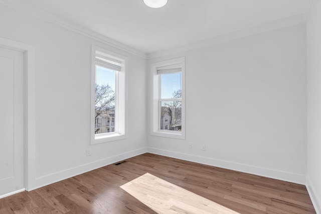 unfurnished room featuring wood finished floors, baseboards, and visible vents