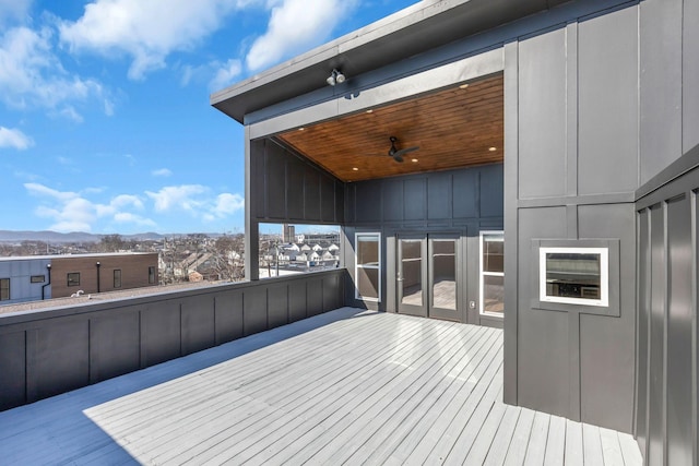 wooden terrace featuring a ceiling fan and a mountain view