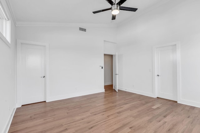 unfurnished bedroom with visible vents, light wood-type flooring, baseboards, and ornamental molding