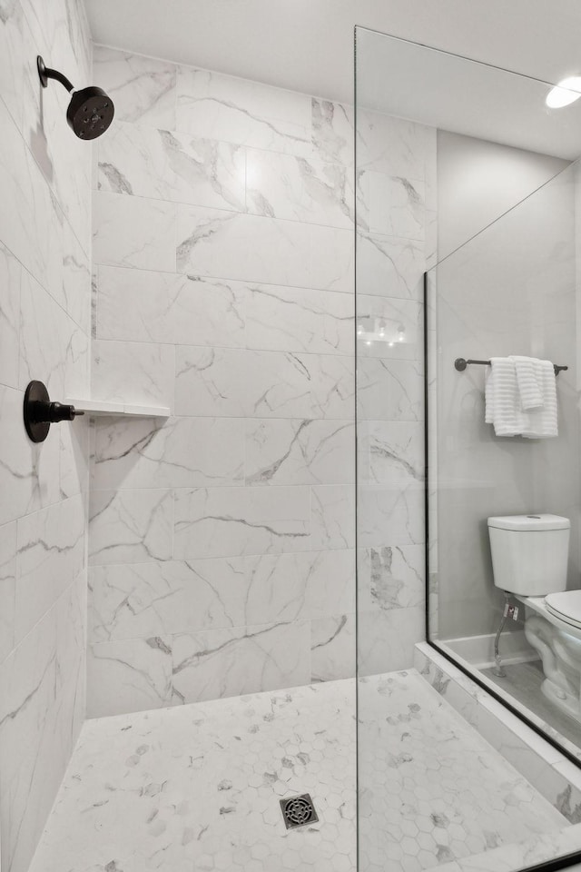 bathroom with toilet and tiled shower