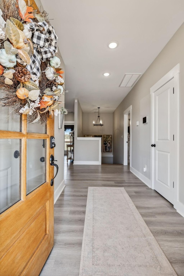 entryway with a chandelier and wood-type flooring