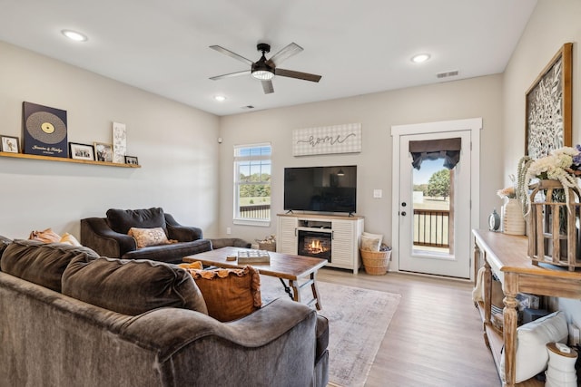 living room featuring light hardwood / wood-style flooring and ceiling fan