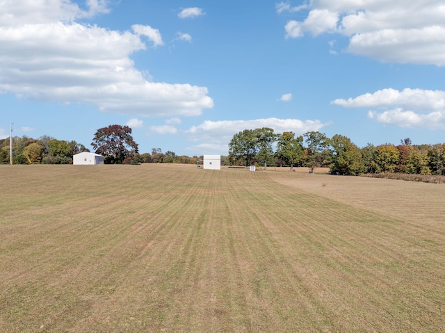 view of yard with a rural view and a storage unit