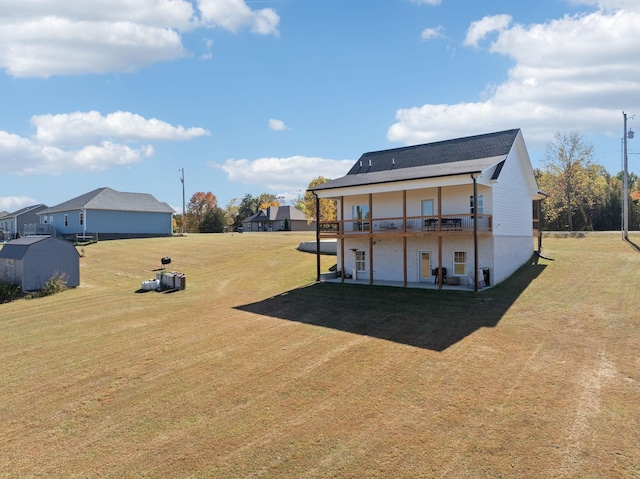 rear view of house featuring a yard, a patio, and a storage unit