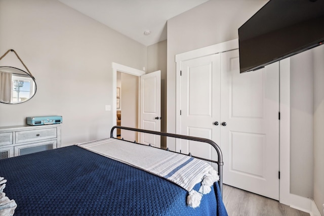 bedroom with light wood-type flooring and a closet