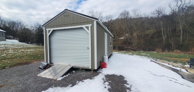 snow covered structure featuring a garage